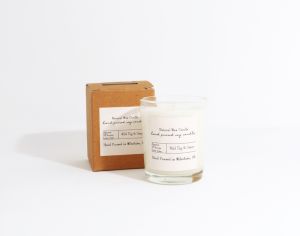 Mini glass candle with branded label to the candle and cardboard box.